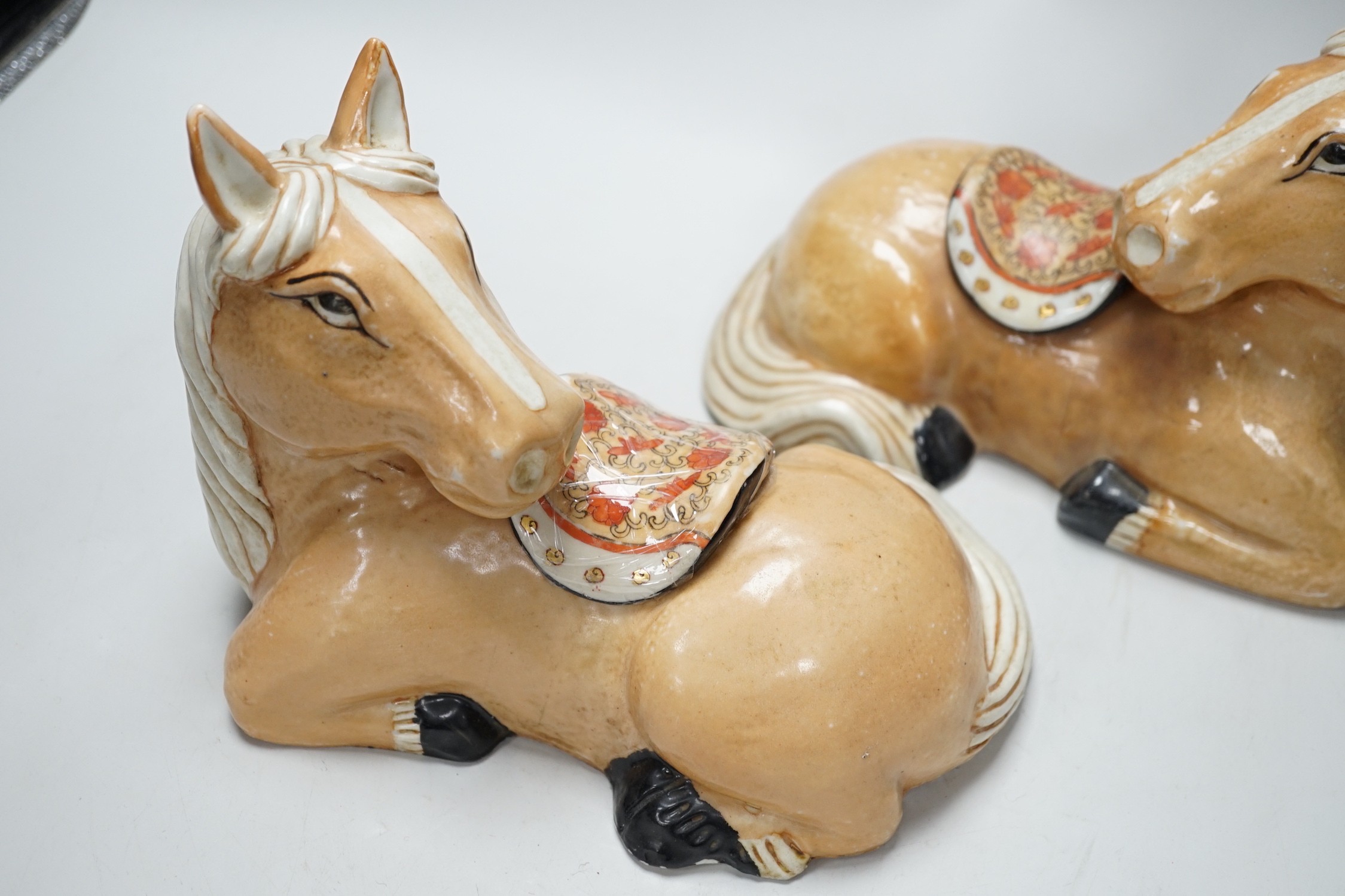 A pair of Chinese ceramic seated horses, 18cm high